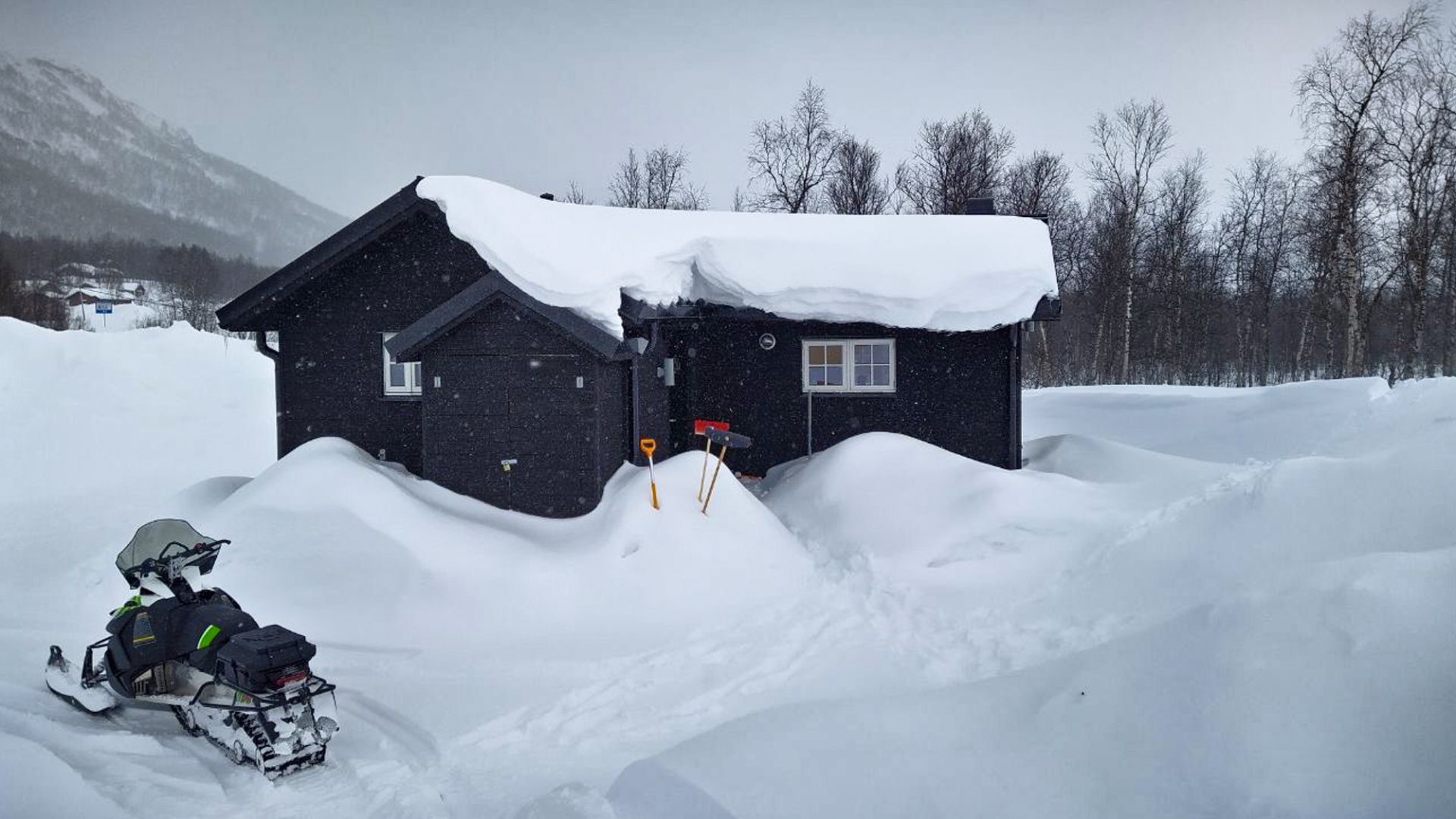 Svart fjällstuga snö